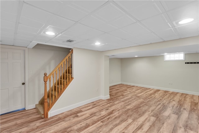 basement featuring hardwood / wood-style flooring and a drop ceiling