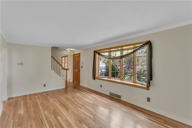 unfurnished room with light wood-type flooring and ornamental molding