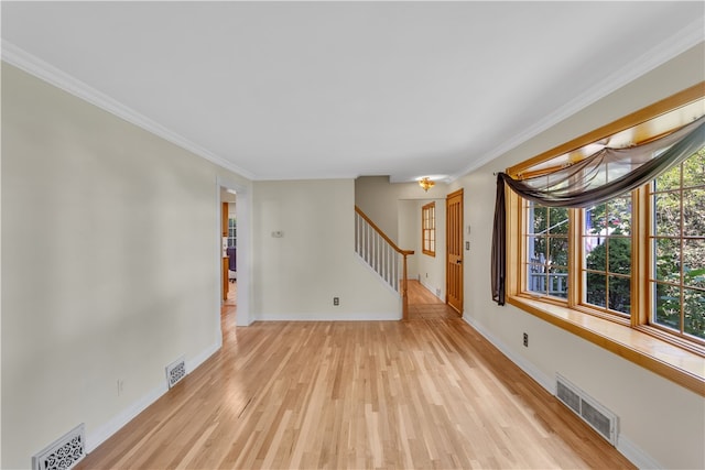 empty room featuring ornamental molding and light wood-type flooring