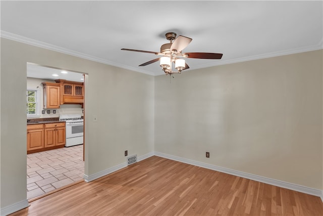 interior space with crown molding, light tile patterned floors, and ceiling fan