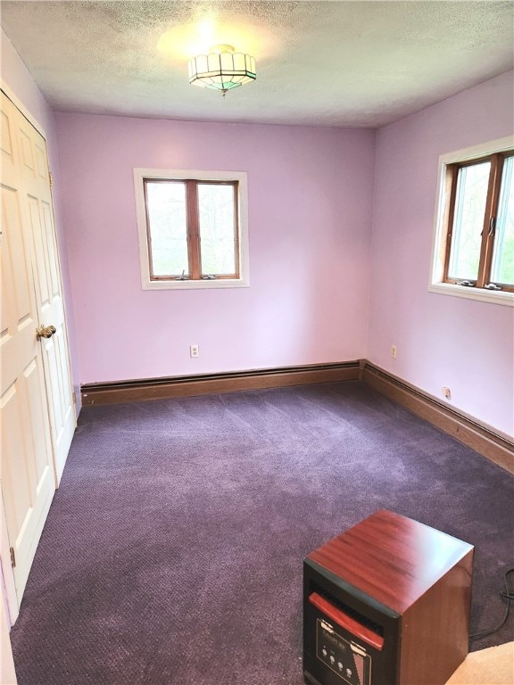 unfurnished room featuring a textured ceiling and carpet flooring