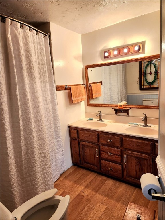 bathroom featuring vanity, toilet, a shower with curtain, and hardwood / wood-style floors