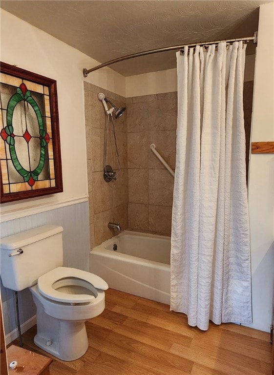 bathroom featuring wood-type flooring, toilet, and shower / bathtub combination with curtain