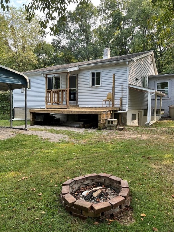 back of house with a fire pit, a yard, and a wooden deck