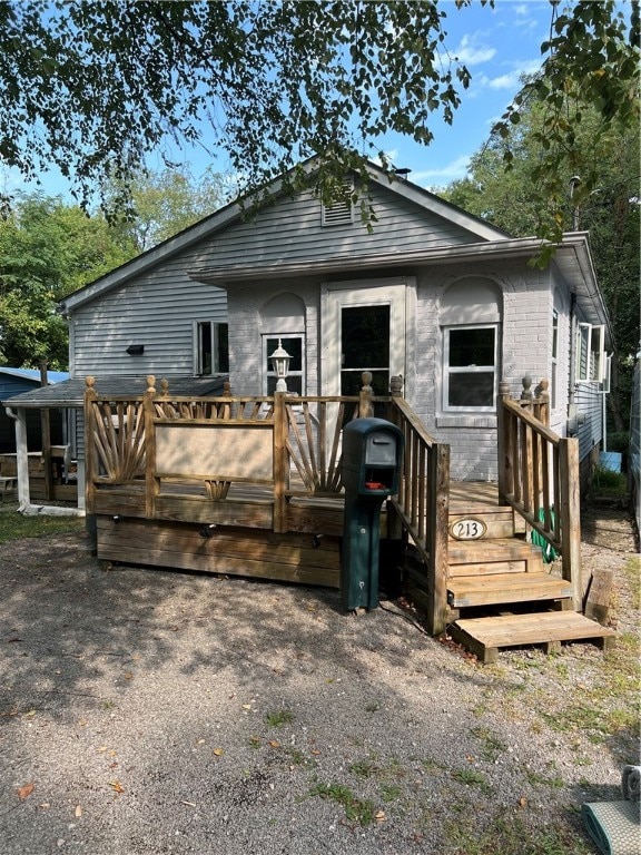 rear view of house featuring a wooden deck