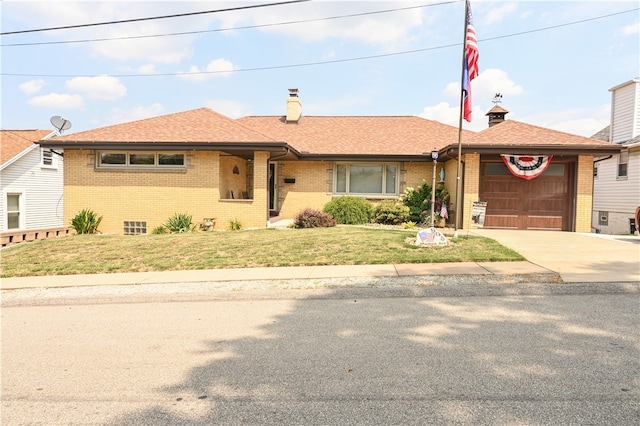 view of front of home with a front yard and a garage