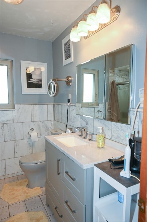 bathroom with vanity, tile walls, toilet, tile patterned floors, and decorative backsplash