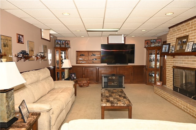 carpeted living room with a fireplace and a drop ceiling