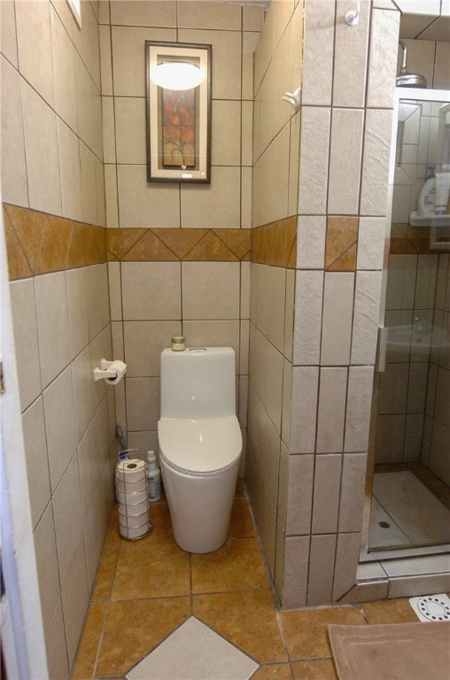 bathroom featuring tile walls, toilet, tiled shower, and tile patterned floors