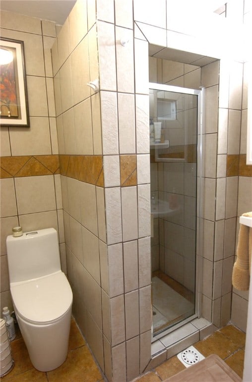 bathroom featuring tile walls, toilet, walk in shower, and tile patterned flooring