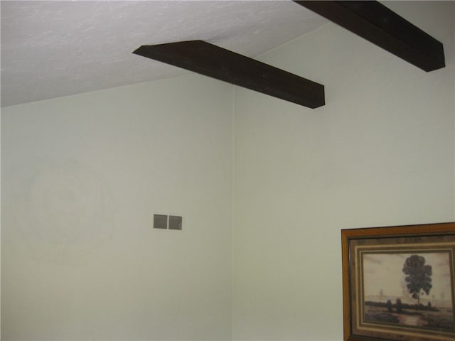 details featuring a textured ceiling and beam ceiling