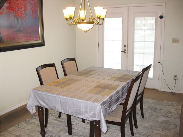 dining area with french doors and a notable chandelier