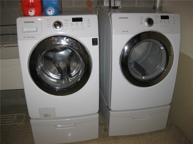 washroom with tile patterned flooring and washer and clothes dryer