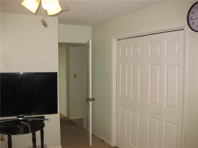 carpeted bedroom featuring ceiling fan and a closet