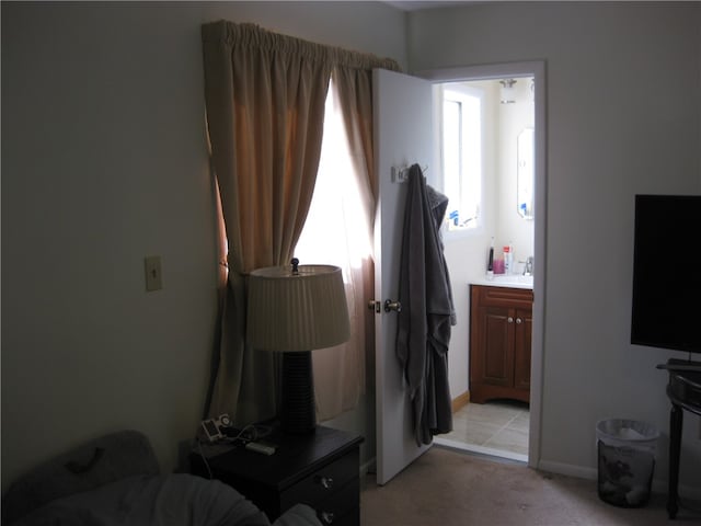 carpeted bedroom with sink and ensuite bath