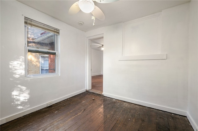 unfurnished room with dark wood-style floors, ceiling fan, and baseboards