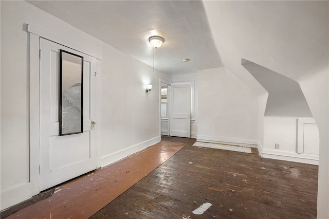 additional living space with hardwood / wood-style floors and baseboards