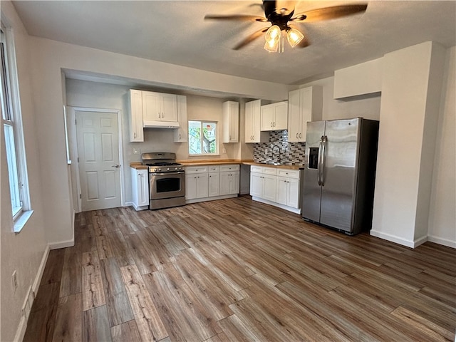 kitchen with ceiling fan, hardwood / wood-style flooring, appliances with stainless steel finishes, and white cabinets