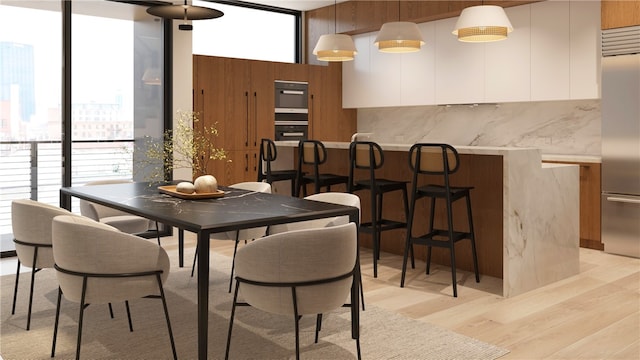 dining room featuring light hardwood / wood-style flooring and a wall of windows