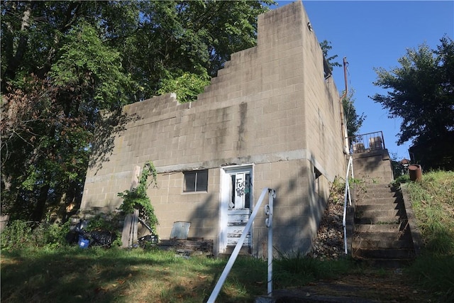 view of property exterior featuring stairway and concrete block siding