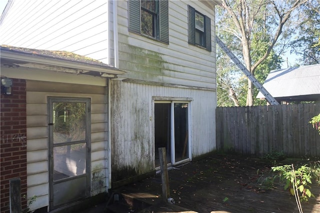 view of home's exterior featuring brick siding and fence