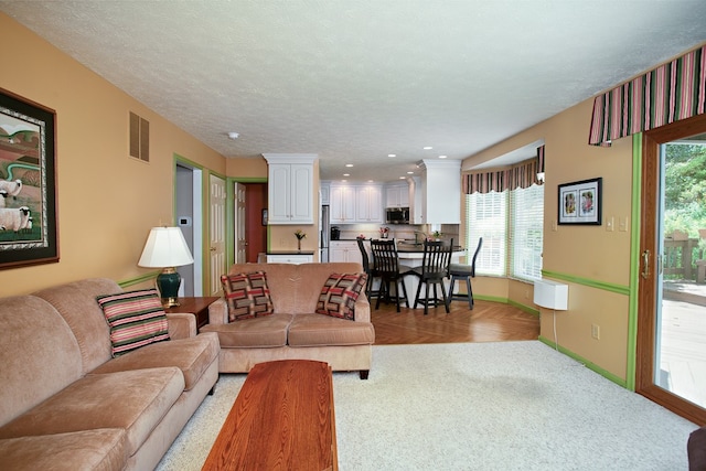 carpeted living room with a textured ceiling