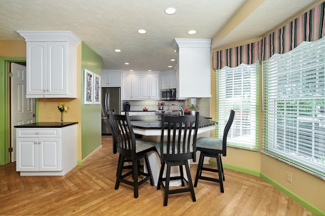 dining space with light parquet floors and a textured ceiling