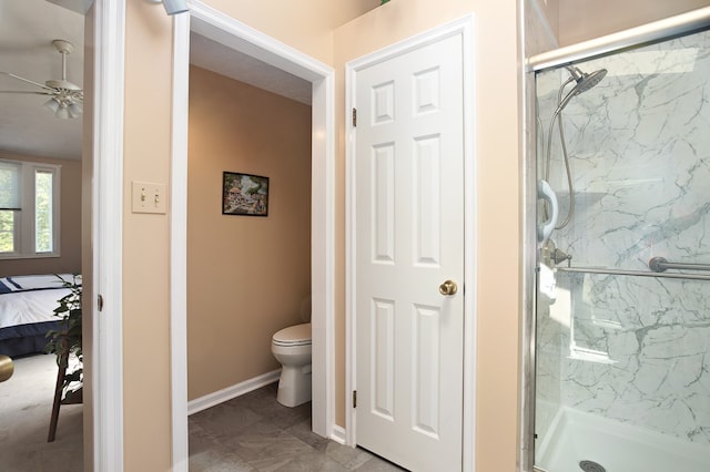 bathroom with toilet, an enclosed shower, and ceiling fan