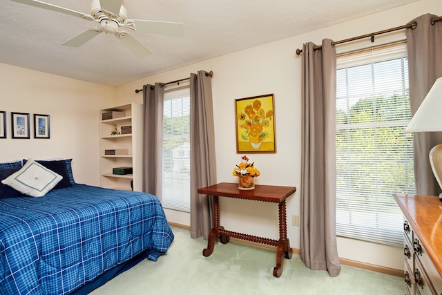 carpeted bedroom featuring a textured ceiling and ceiling fan