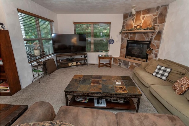 living area with a stone fireplace, a wealth of natural light, and carpet
