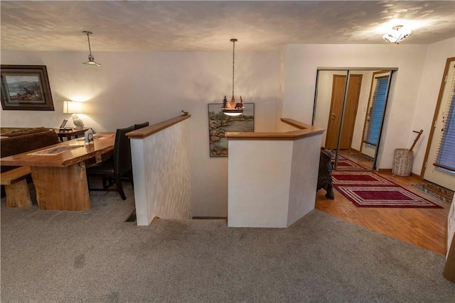 bar with decorative light fixtures, wood finished floors, and carpet