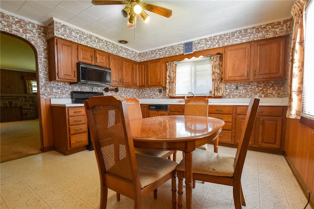 kitchen with ornamental molding, backsplash, wood walls, and ceiling fan