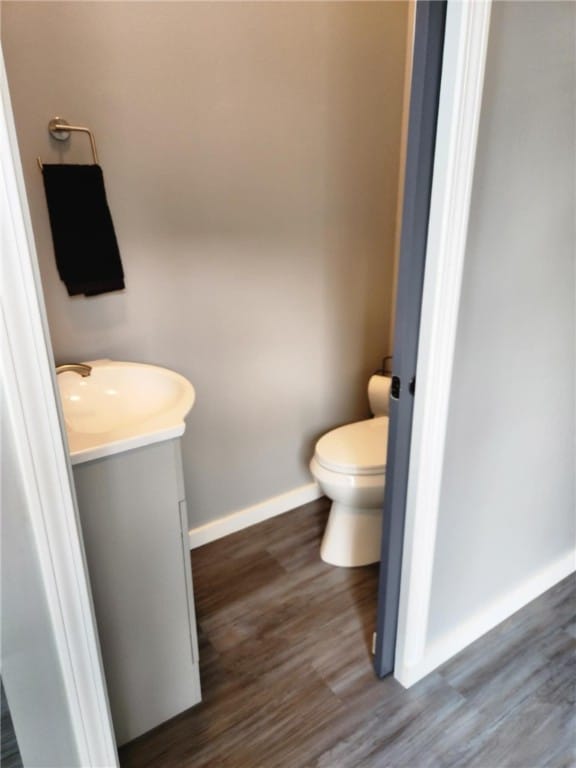 bathroom with vanity, toilet, and hardwood / wood-style flooring