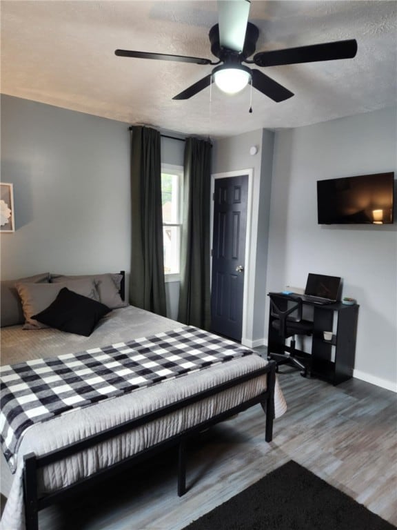 bedroom featuring a textured ceiling, ceiling fan, and hardwood / wood-style floors