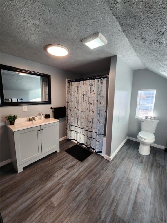 bathroom with wood-type flooring, toilet, a textured ceiling, and vanity