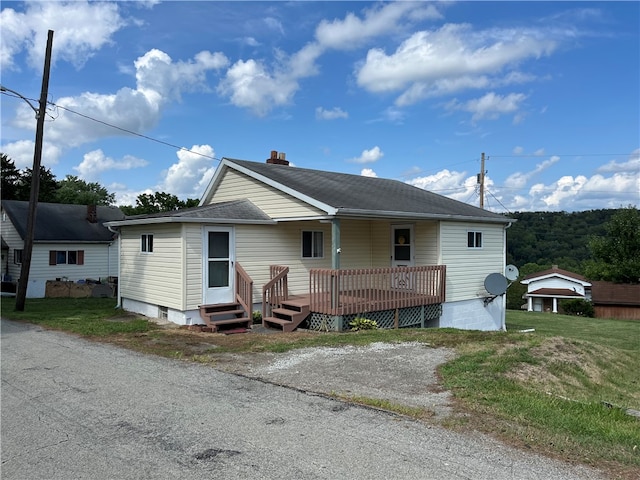 view of front of property with a front yard and a deck