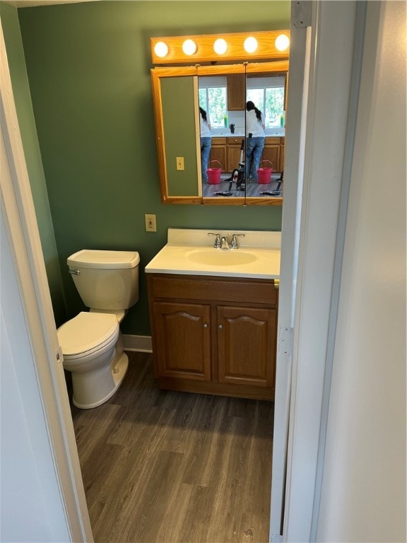 bathroom featuring toilet, hardwood / wood-style flooring, and vanity