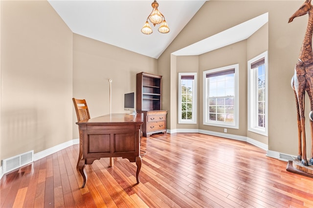 office area with a notable chandelier, light wood-type flooring, and high vaulted ceiling