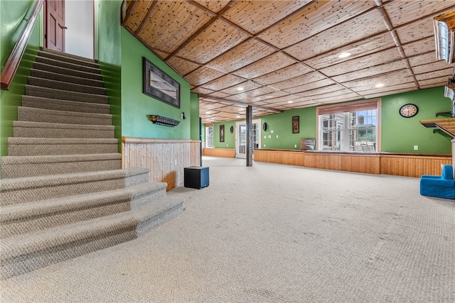 interior space with carpet flooring and wood walls