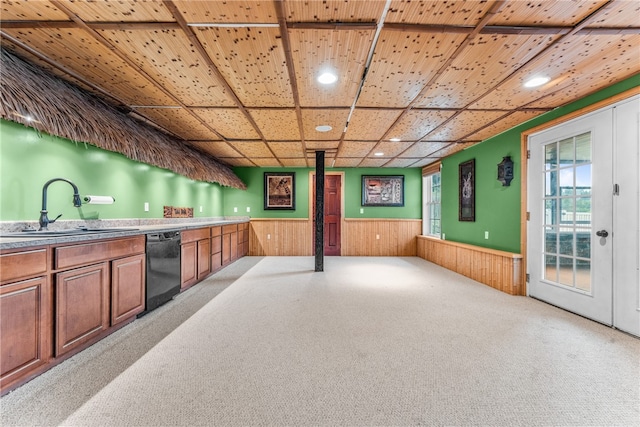 kitchen with a healthy amount of sunlight, sink, light colored carpet, and black dishwasher