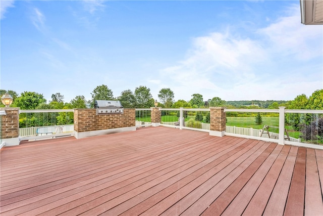 wooden terrace with an outdoor kitchen and area for grilling