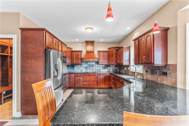 kitchen with stainless steel refrigerator with ice dispenser, sink, hanging light fixtures, and custom exhaust hood