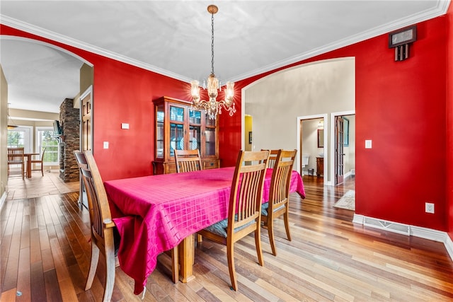 dining area featuring hardwood / wood-style floors, crown molding, and a chandelier