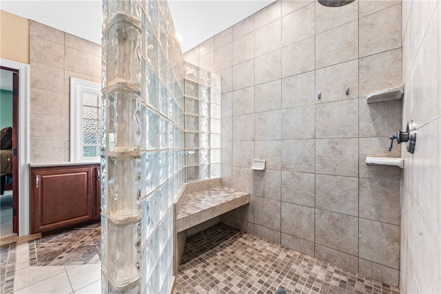 bathroom featuring tile patterned flooring, tile walls, and tiled shower