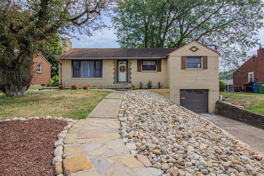 ranch-style house featuring a garage and a front lawn