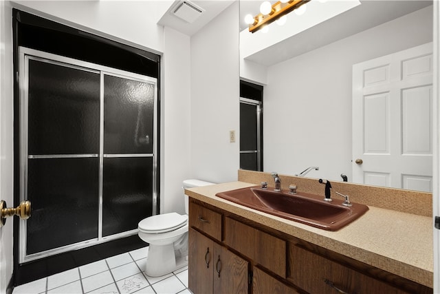 bathroom featuring vanity, toilet, a shower with shower door, and tile patterned floors