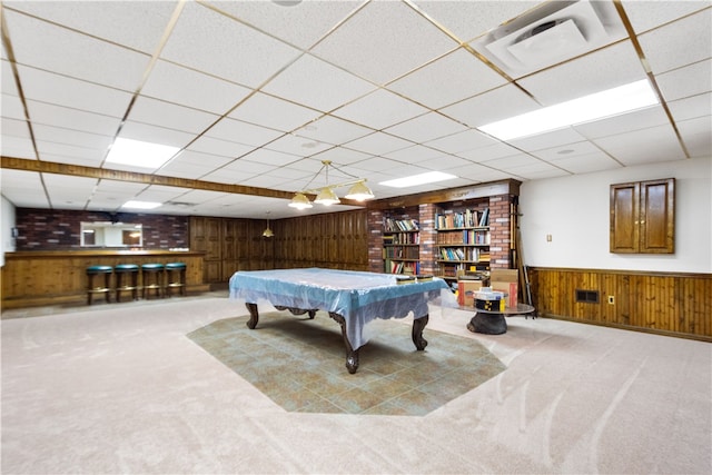 playroom with a paneled ceiling, pool table, wooden walls, and carpet