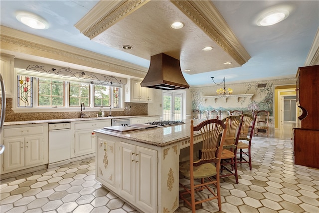 kitchen featuring light stone counters, premium range hood, a kitchen breakfast bar, a kitchen island, and tasteful backsplash