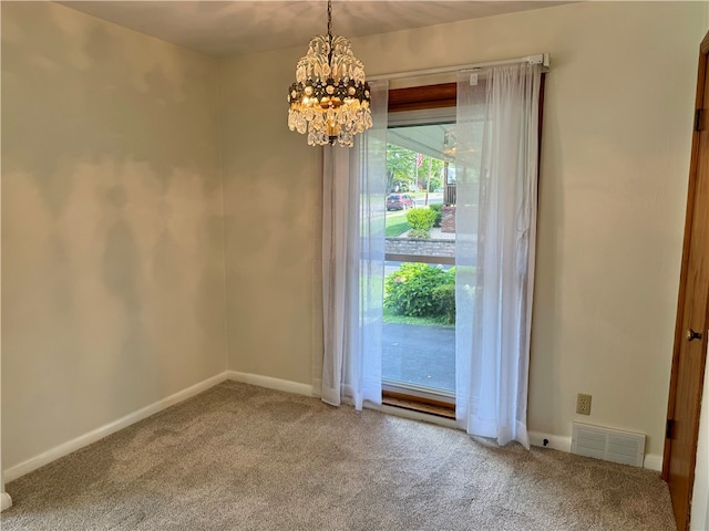 spare room with a notable chandelier and carpet floors