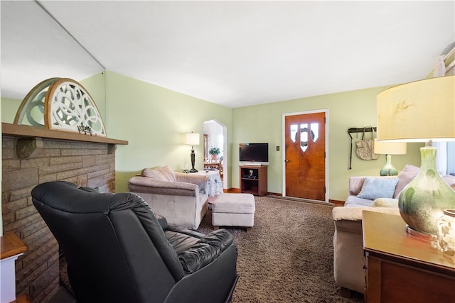 living room featuring vaulted ceiling, a stone fireplace, and carpet floors